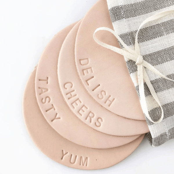 leather coaster set displaying hand-pressed words